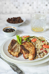 Baked pieces of meat with brown rice and vegetables