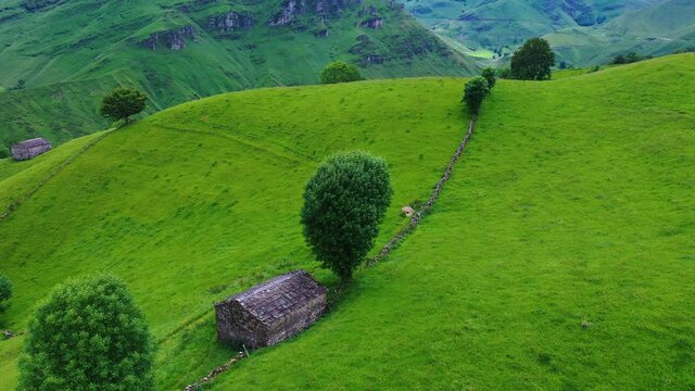 Aerial view with a drone of the spring landscape of pasiegas cabins and meadows in the Miera Valley in the Autonomous Community of Cantabria. Spain, Europe