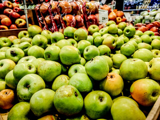 green fresh apples are piled up in the store for sale