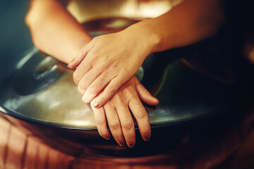 beautiful woman playing with hangdrum in nature.
