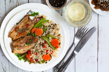 Baked pieces of pork with brown rice and vegetables