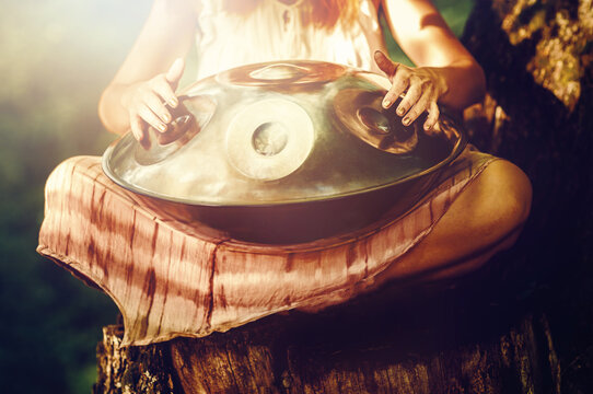 beautiful woman playing with hangdrum in nature.