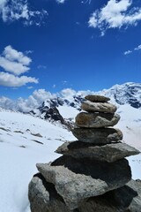 Stone cairns in the Swiss mountains in Graubünden with the Piz Palü in the background