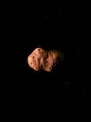 Obraz na płótnie Canvas Rocky asteroid with craters in space. Asteroid isolated on a black background. 