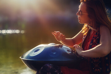 beautiful woman playing with hangdrum in nature.