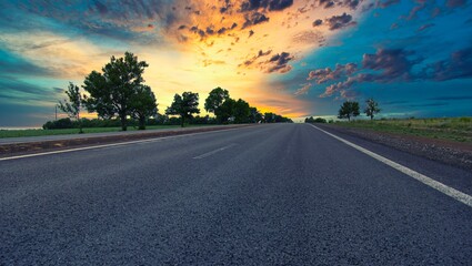 highway goes to the horizon between the fields