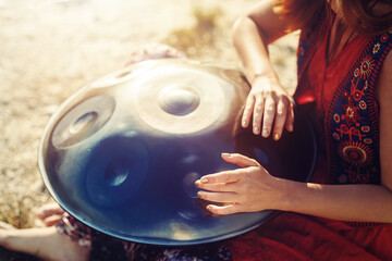 beautiful woman playing with hangdrum in nature.