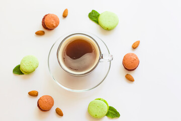 A cup of coffee on a white background in a circle lie macaroons with mint. TIsolate. Morning coffee