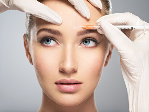  woman getting cosmetic botox injection in forehead