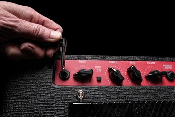 Guitar cable into an amplifier with drive, bass and treble controls