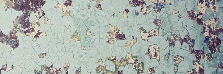 Peeling paint on the wall. Panorama of a concrete wall with old cracked flaking paint. Weathered rough painted surface with patterns of cracks and peeling. Wide panoramic texture for grunge background