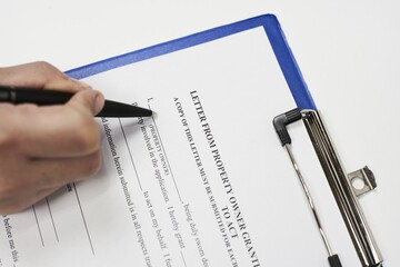 Closeup of a person signing a Property authorization letter