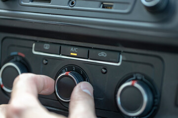 Male hand adjusts the level of air conditioning in the car