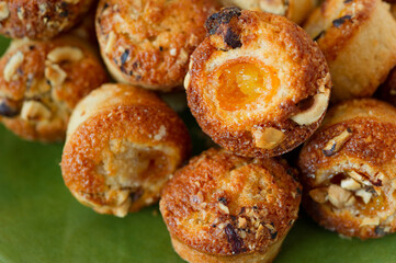 citrus orange like fruit kumquat almond muffins or cupcakes on a  green plate, sideview closeup 