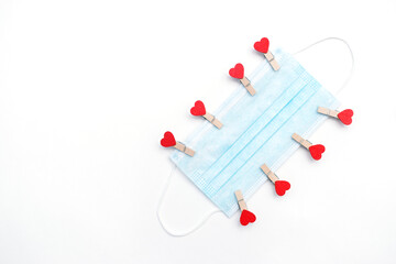  Protective medical mask with wooden clothespins with hearts on a white background.Concept of gratitude and support to healthcare workers. Concept of love in new normal reality. Copy space, flat lay