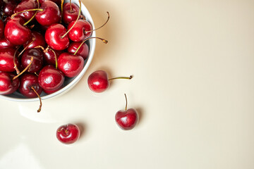 Naklejka na ściany i meble Cherries in bolw on light background
