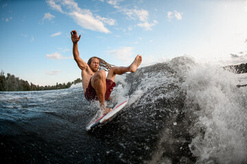 Fototapeta premium young wakesurf man falls from board on wave.