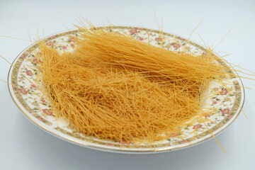 uncooked rice vermicelli pasta on a white background