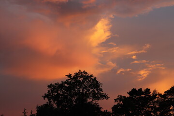 Fototapeta premium zachód słońca nad miastem i wielkie chmury