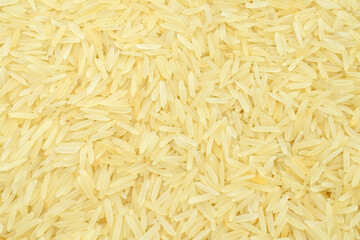 Brown long rice background, uncooked raw cereals, macro closeup