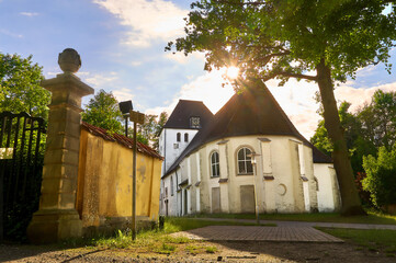 backside view of the historic lutheran church St. Nicolai in Holdenstedt (Uelzen, Germany) against beautiful evening sunlight during summer (text on sign means translated "transit by car forbidden")