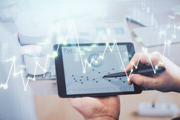 Double exposure of man's hands holding and using a phone and financial chart drawing. Market analysis concept.