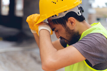 A tired construction worker wiped his head