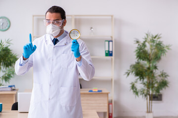 Fototapeta premium Young male doctor virologist in the office