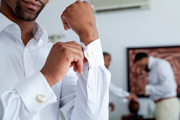 Cufflinks putting on the skirt during groom getting ready morning. Cufflink for wedding marriage ceremony