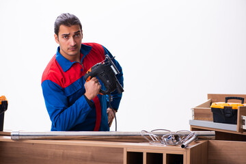 Young handsome male carpenter working indoors