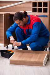 Young handsome male carpenter working indoors
