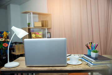 Business computer office desk with desktop laptop, notebook, lamp and cactus, working space at home office. Business executive office table concept.