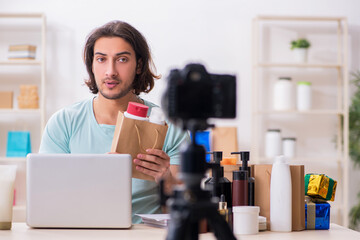 Young male shopaholic recording video for his blog