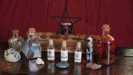 Wiccan altar with potion, pentagram, crystals, traditional herbs in jars, incense burning