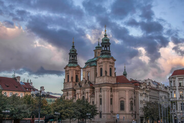 St. Nicholas Church Prague Old Town Square at dawn with dramatic sky and clouds no people