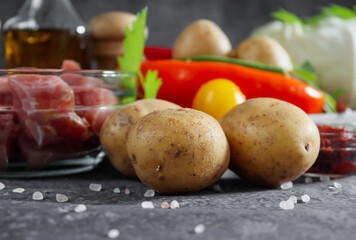
three potatoes with meat and vegetables on a stone background, closeup side view.