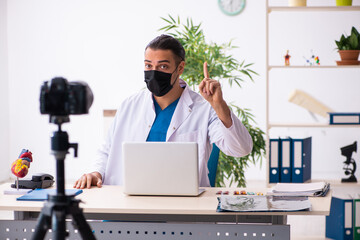 Young male doctor recording video for his blog