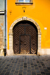 Large elegant brown door in a building with yellow walls. Historical heritage in the European city of Budapest, Hungary.