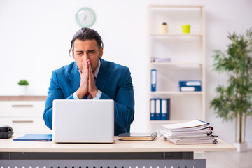 Sick male employee suffering at workplace from coronavirus