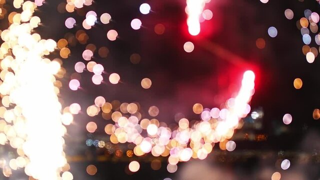 Firework burning on the beach - red fireworks spinning around and spreads sparkles