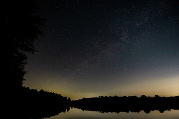 Stars and milky way reflected on the lake at night in Michigan