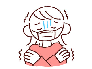 寒気で震えるマスク姿の若い女性