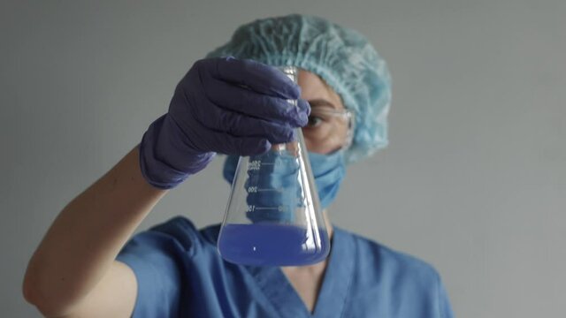 Scientist working in laboratory, processing of the laboratory sample in an Erlenmeyer flask, titration with reagent from a burette.