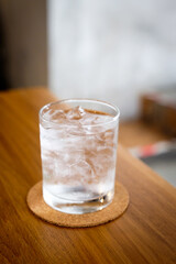 A glass of cold drinking water on wooden table