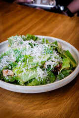 A fresh caesar salad on a wooden table