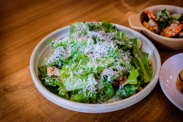 A fresh caesar salad on a wooden table