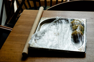 A wooden rolling pin with pasta dough
