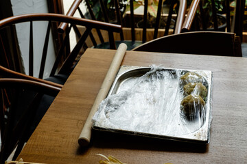 A wooden rolling pin with pasta dough