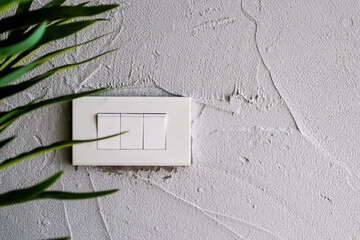 Isolated white light switch on grunge wall background