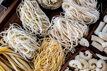 Varieties of dry pasta on a wooden plate